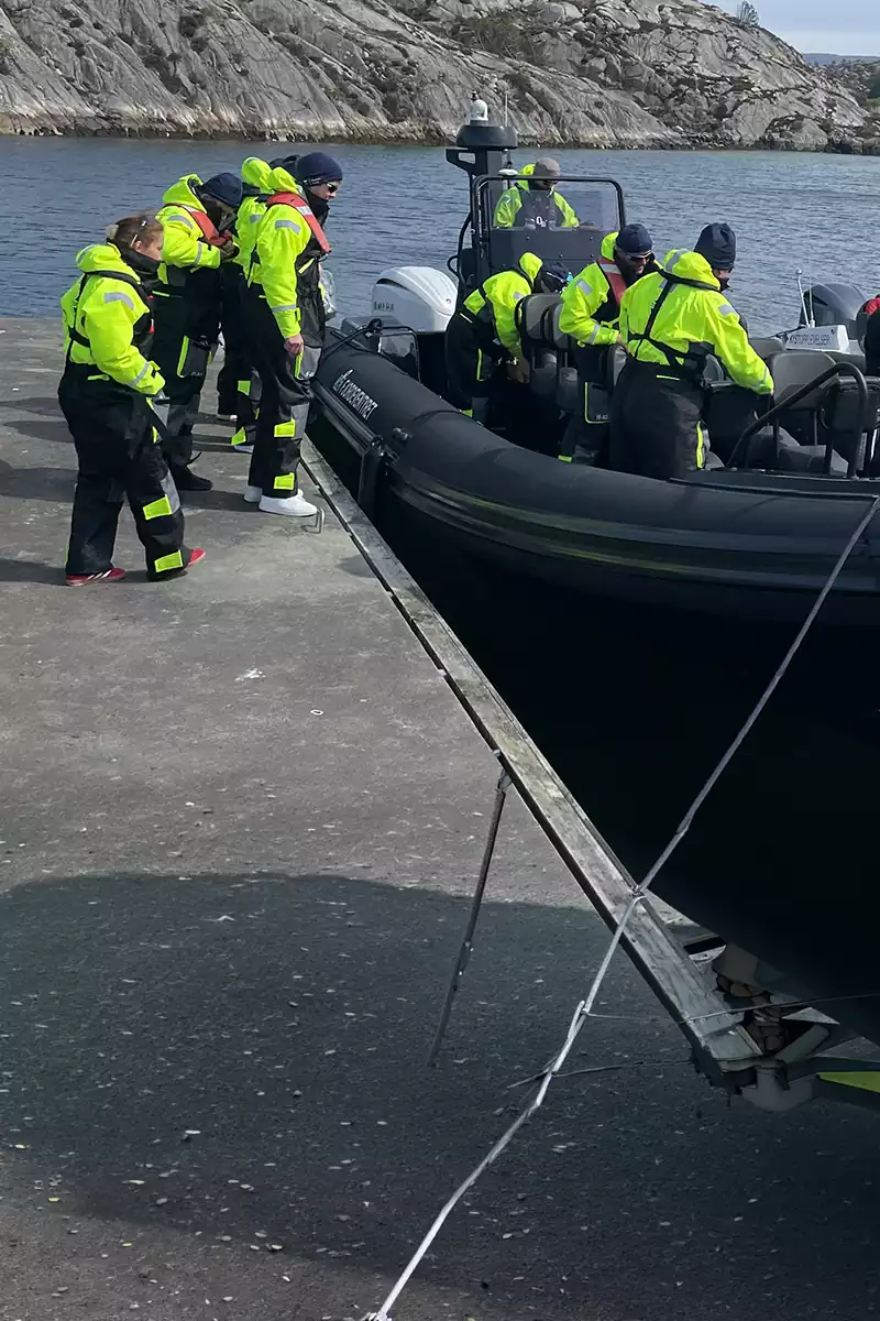 Passasjerer går om bord i en RIB-båt ved kai